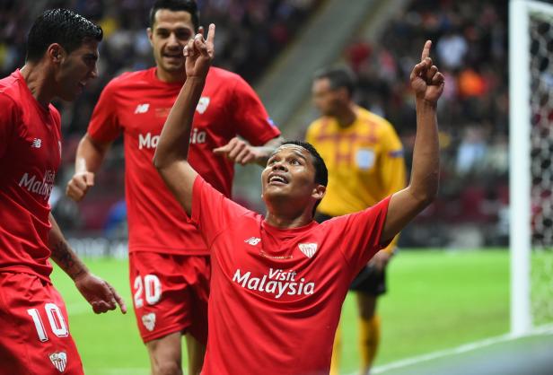 Ein Fußballspieler von Sevilla feiert mit erhobenem Zeigefinger ein Tor.