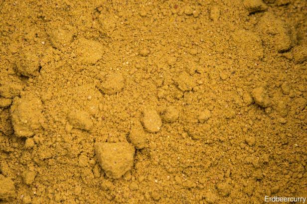 Nahaufnahme von Currypulver mit gelb-brauner Farbe.