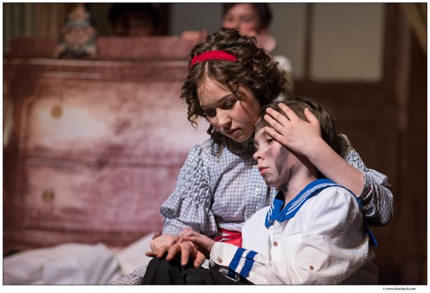 Ein Mädchen tröstet einen Jungen mit schwarzem Schmutz im Gesicht.