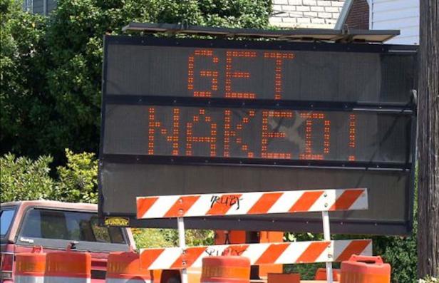 Eine elektronische Anzeigetafel zeigt die Worte „Get Naked!“.
