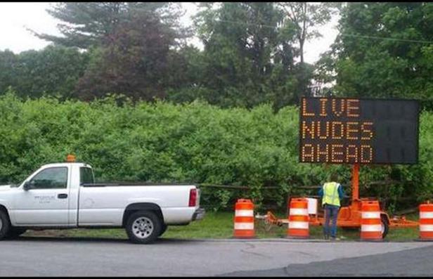 Ein Verkehrsschild zeigt die möglicherweise gefälschte Nachricht „Live Nudes Ahead“ an.