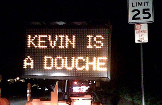 Eine elektronische Anzeigetafel zeigt die Nachricht „Kevin is a Douche“.