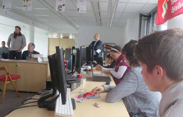 Mehrere Personen arbeiten in einem hellen Büro an Computern.