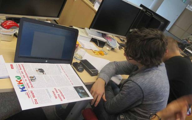 Ein Schreibtisch mit einem Laptop und einer Zeitung über die Bundespräsidentenwahl in Österreich.