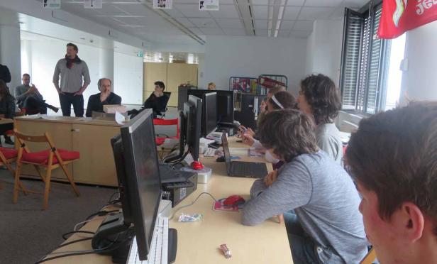 In einem Büro sitzen mehrere Personen an Computern und arbeiten.