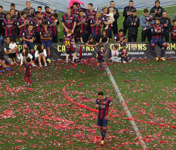 Spieler des FC Barcelona feiern einen Titelgewinn auf dem mit Konfetti bedeckten Rasen.