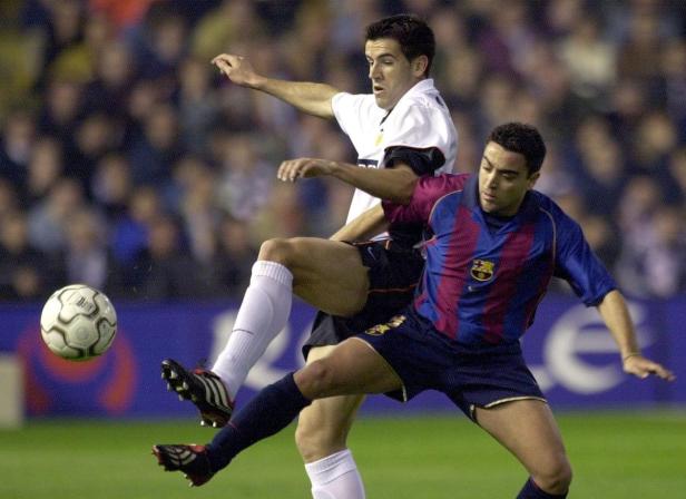 Zwei Fußballspieler kämpfen um den Ball auf dem Spielfeld.