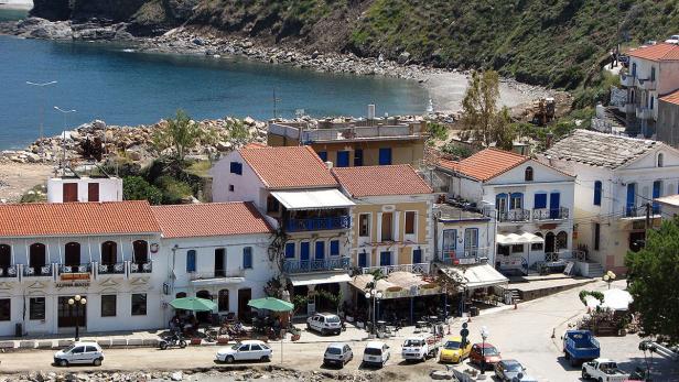 Blick auf eine Küstenstadt mit traditionellen Häusern und einem kleinen Strand.