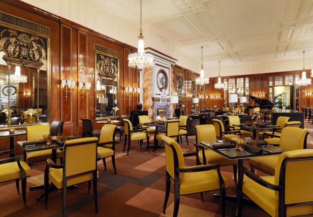 Ein elegantes Restaurant mit gelben Stühlen und dunklen Tischen.