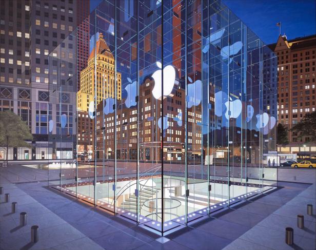 Das Apple-Geschäft in einem Glasgebäude in einer städtischen Umgebung bei Nacht.
