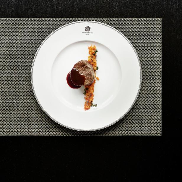 Ein Teller mit einem Filetsteak mit Soße und Gemüsebeilage im Hotel Bristol Wien.