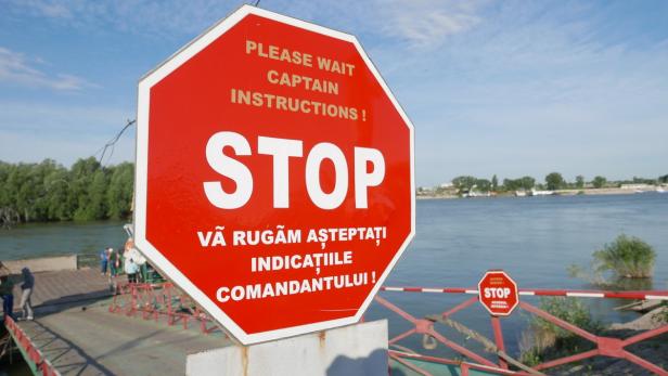 Ein rotes Stoppschild auf einer Fähre mit der Aufschrift „Bitte warten Sie auf Anweisungen des Kapitäns!“.