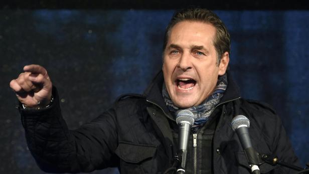 Ein Mann gestikuliert und spricht in ein Mikrofon.