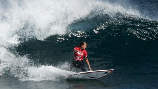 Eine Frau reitet auf einem Surfbrett eine Welle.