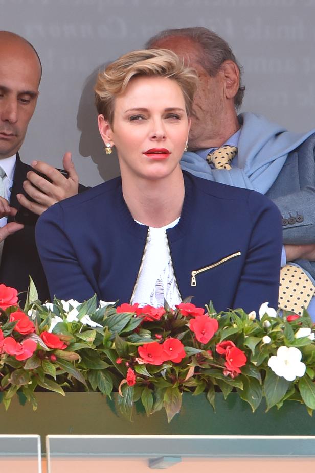 Fürstin Charlène von Monaco bei einer Veranstaltung hinter einem Blumenkasten.
