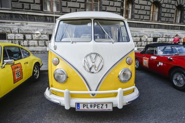 Ein gelb-weißer VW-Bus steht auf der Straße.