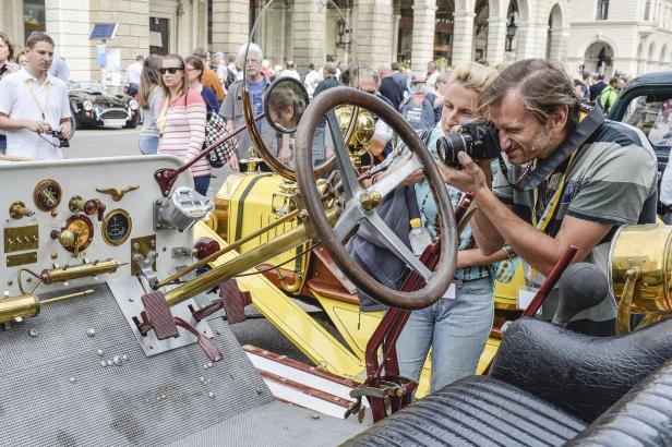 Ein Paar fotografiert das Armaturenbrett eines Oldtimers.