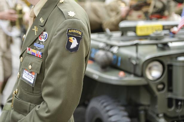 Ein Soldat in Uniform der 101. Luftlandedivision steht vor einem Militärfahrzeug.