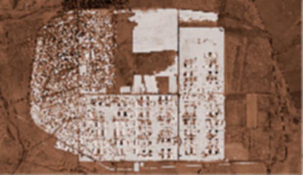 Eine Luftaufnahme einer Stadt mit Wohngebieten und Industrieanlagen.