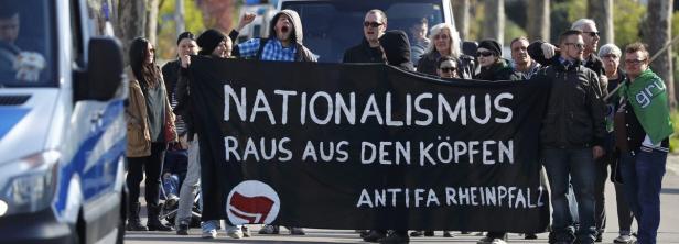 Eine Gruppe von Menschen demonstriert mit einem Banner gegen Nationalismus.