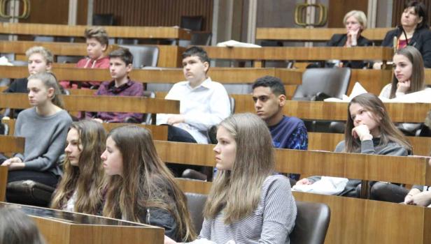 Eine Gruppe Jugendlicher sitzt in einem Auditorium.