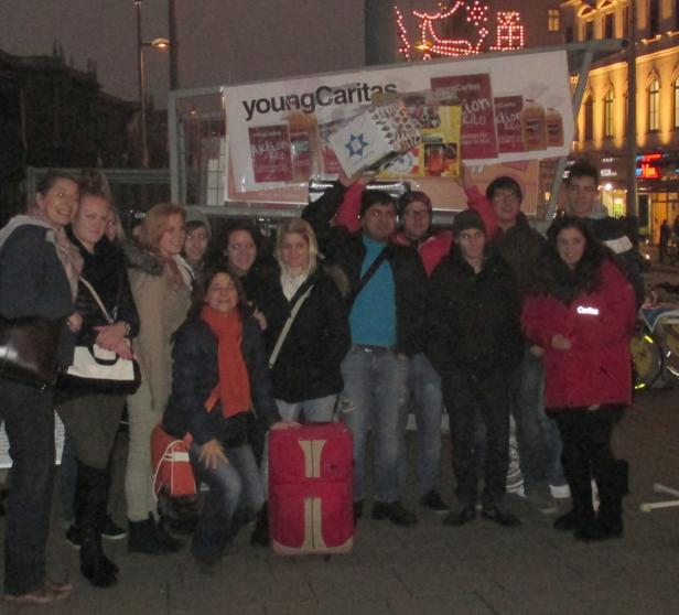 Eine Gruppe junger Leute posiert vor einem „Young Caritas“-Banner.