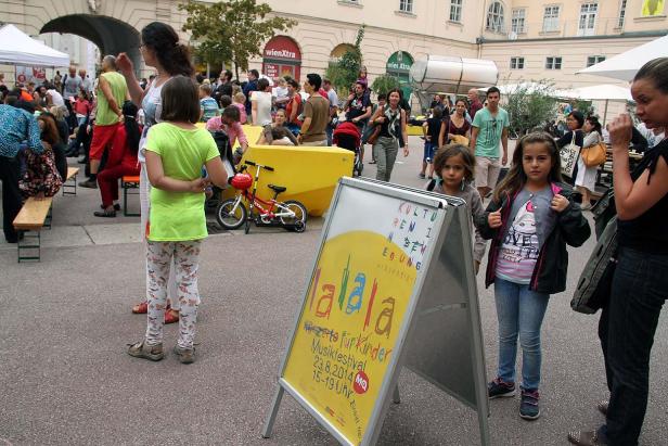 Zwei Mädchen stehen vor einem Plakat für das „lalala Kinder Musikfestival“.