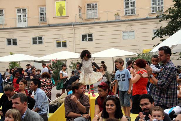 Eine junge Tänzerin tritt vor einem Publikum im Freien auf.
