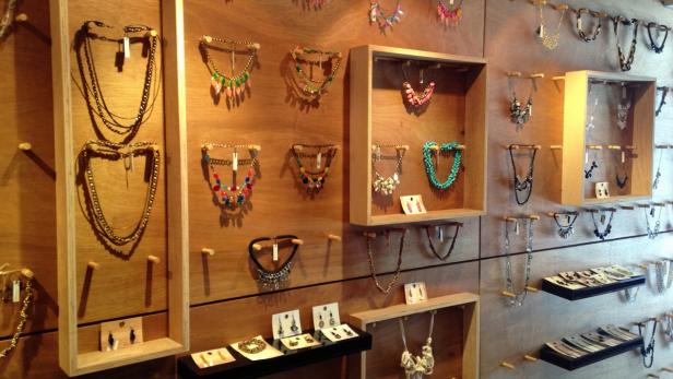 Eine Wand voller verschiedener Halsketten und Ohrringe in einem Schmuckgeschäft.