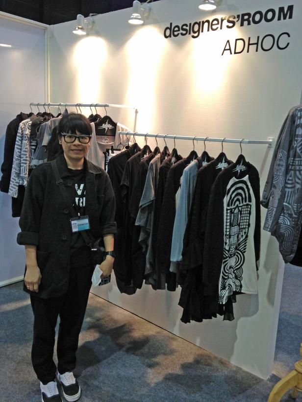 Eine Frau steht vor einem Kleiderständer im „designers' ROOM ADHOC“.