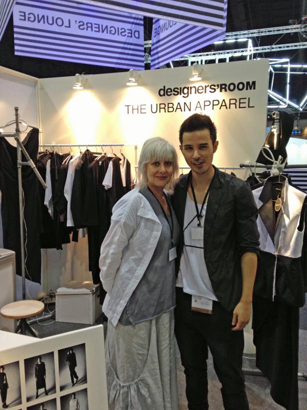 Zwei Personen stehen vor dem Stand „designers' ROOM THE URBAN APPAREL“.