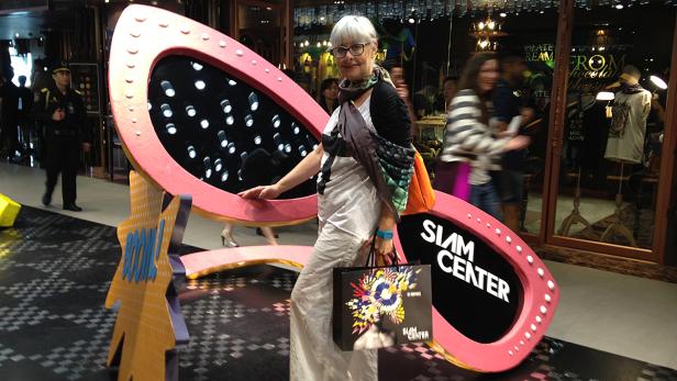 Eine Frau posiert vor einer übergroßen Sonnenbrille mit der Aufschrift „Siam Center“.