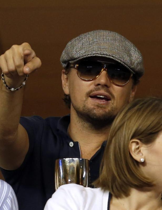 Leonardo DiCaprio mit Schiebermütze und Sonnenbrille gestikuliert mit dem Finger.