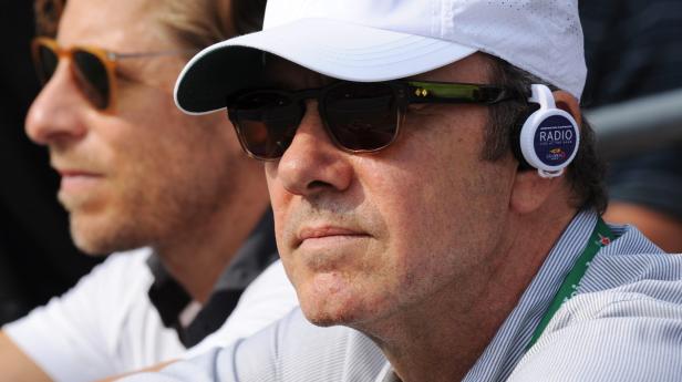Zwei Männer, einer mit Sonnenbrille und einem Radio-Headset, schauen zu.