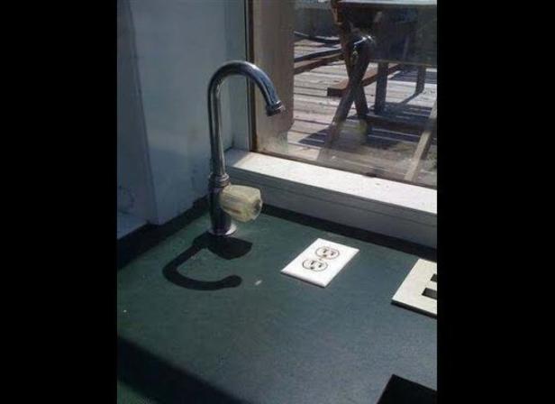 Ein Wasserhahn und eine Steckdose befinden sich nebeneinander auf einer grünen Oberfläche.