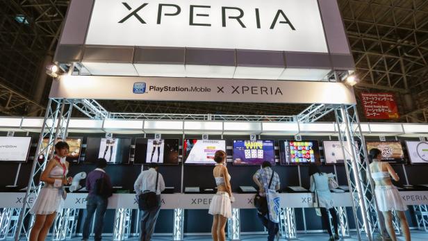 Besucher an einem Stand von Playstation Mobile X Xperia auf einer Messe.