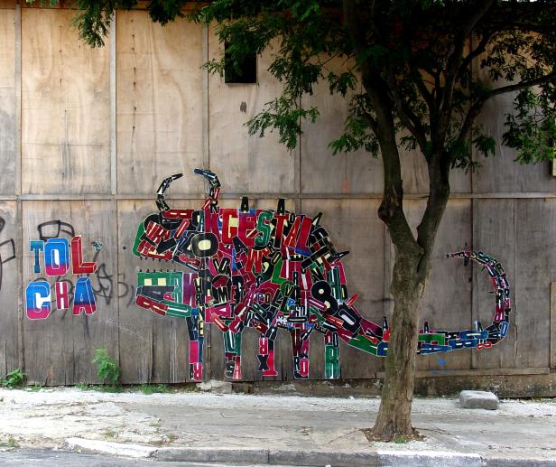 Ein buntes Graffiti in Form eines Tieres an einer Holzwand.