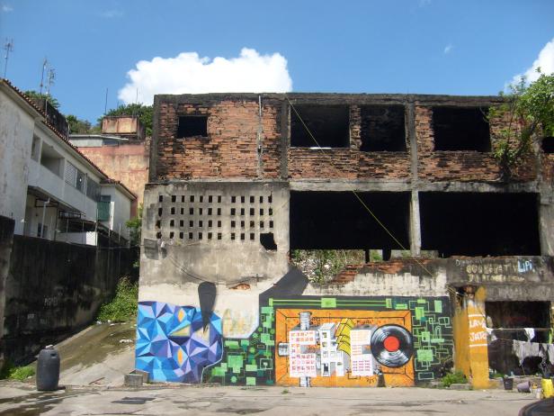 Ein verlassenes Gebäude mit Graffiti an der Fassade unter blauem Himmel.