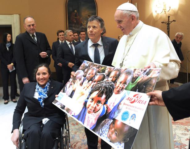 Papst Franziskus hält ein Poster mit afrikanischen Kindern in den Händen.