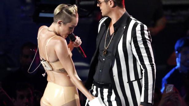 Miley Cyrus singt mit Robin Thicke bei einem Auftritt.