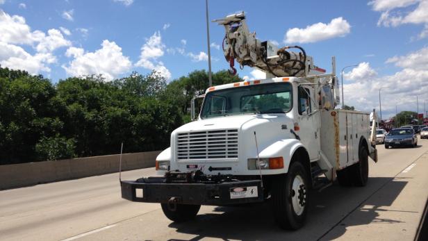 Ein weißer Hubwagen fährt auf einer Autobahn.