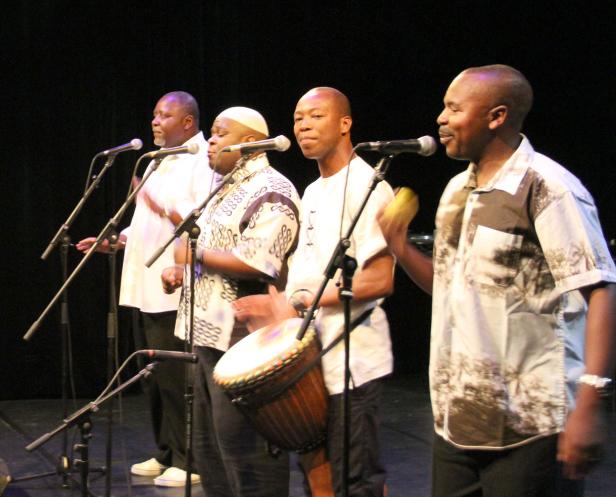 Eine afrikanische Musikgruppe tritt auf einer Bühne auf.