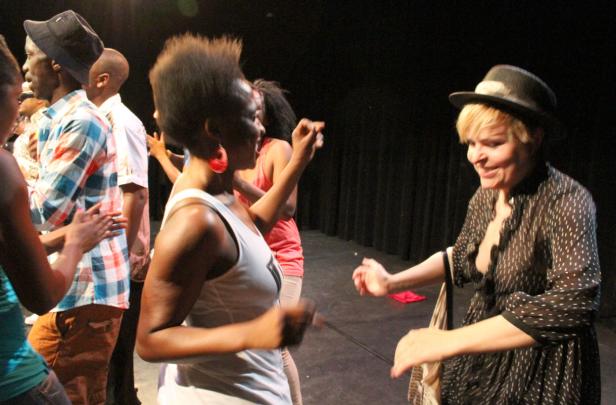 Eine Gruppe von Menschen tanzt auf einer Bühne.