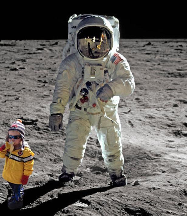 Ein Astronaut steht auf dem Mond neben einem kleinen Kind in Winterkleidung.