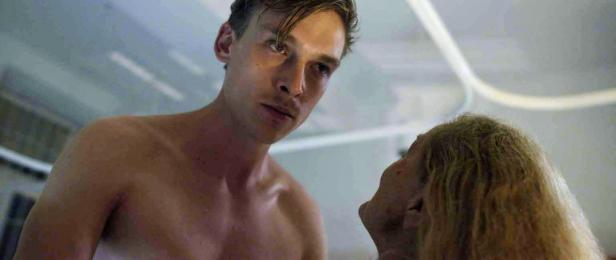 Ein junger Mann blickt aufmerksam auf eine ältere Person.