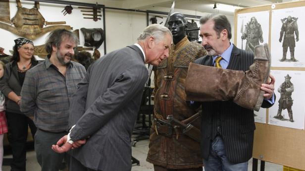 Peter Jackson zeigt Prinz Charles einen Requisite-Stiefel aus der „Hobbit“-Trilogie.