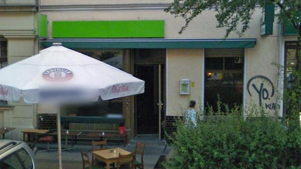 Einladende Bar mit Tischen im Freien und einem Sonnenschirm von Erdinger Weißbier.