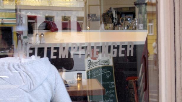 Ein Blick durch das Fenster eines Restaurants mit der Aufschrift „Weltempfänger“.