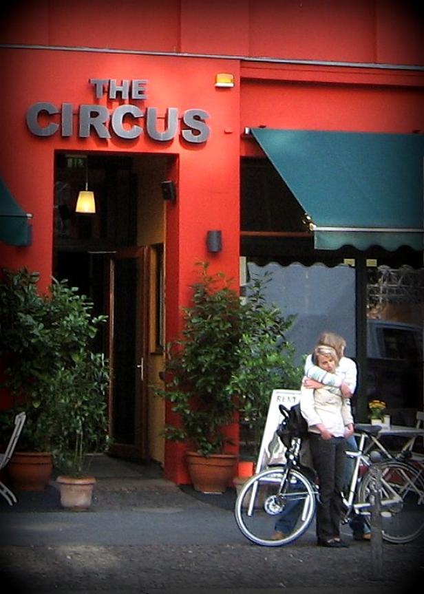 Vor dem Eingang des „The Circus“ stehen zwei Frauen mit Fahrrädern.
