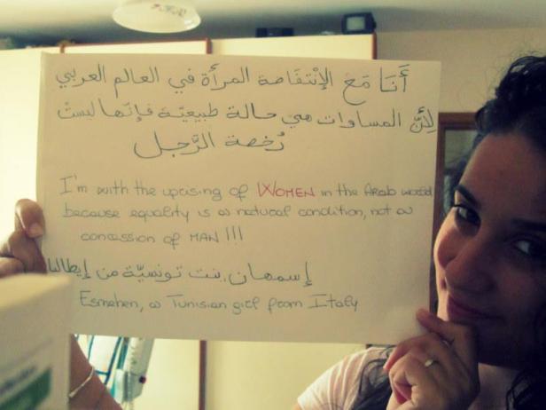 Eine junge Frau hält ein Schild mit arabischer und englischer Schrift, das die Rechte der Frau unterstützt.